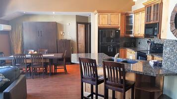 A modern kitchen with granite countertops, wooden cabinets, and a built-in oven.