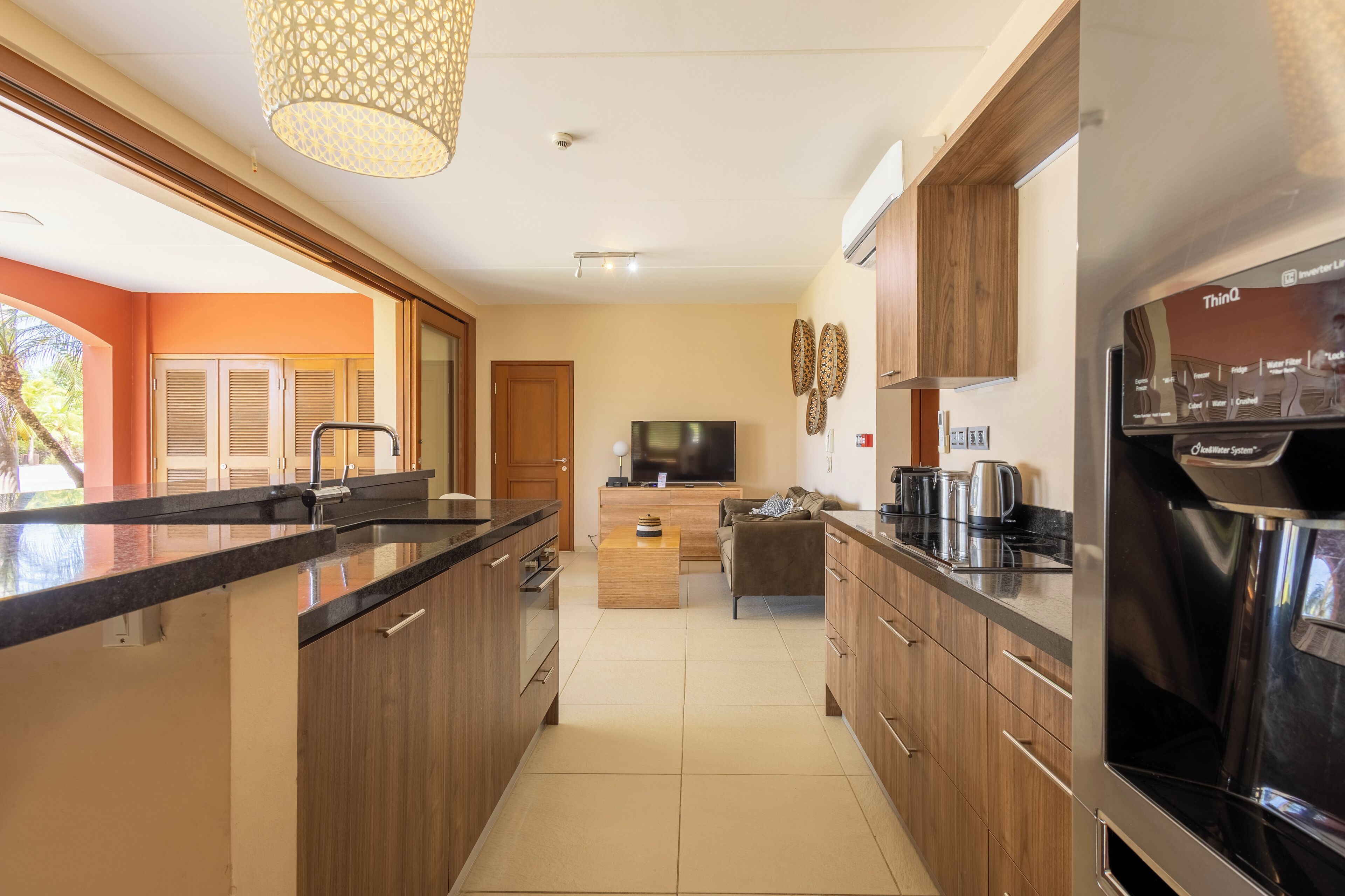 Una cocina moderna con armarios de madera, una isla central, horno integrado y un refrigerador grande.