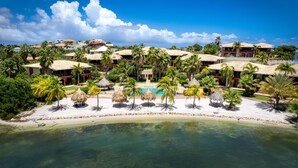 A resort with a pool, palm trees, and beach. - Spanish Water Apartments (Jan Thiel)
