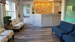 A reception area with a stone wall, a reception desk, and seating arrangements. - Sunset Mountain Inn and Spa (Canmore)
