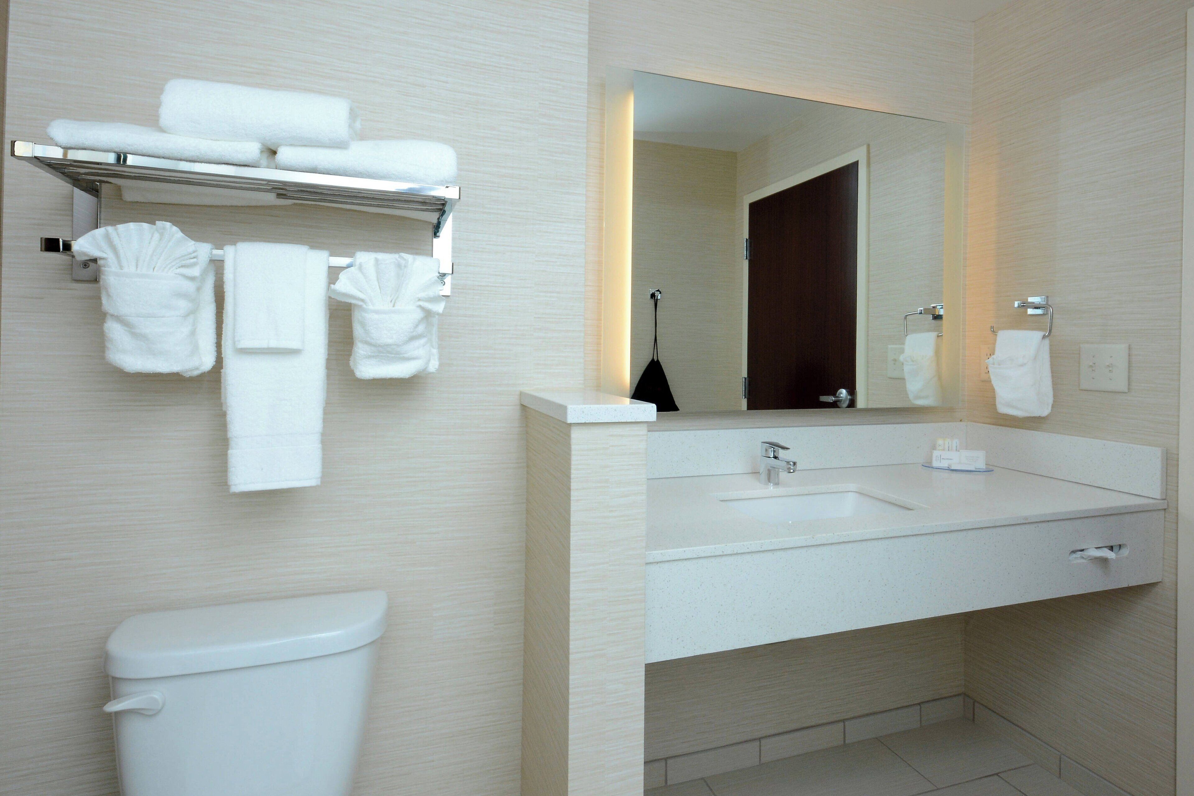 A modern bathroom with a toilet, a sink, and a mirror.