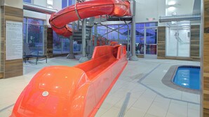 Ein Wasserrutschenbereich im Innenbereich mit einem klaren Weg und einem Pool am Ende.