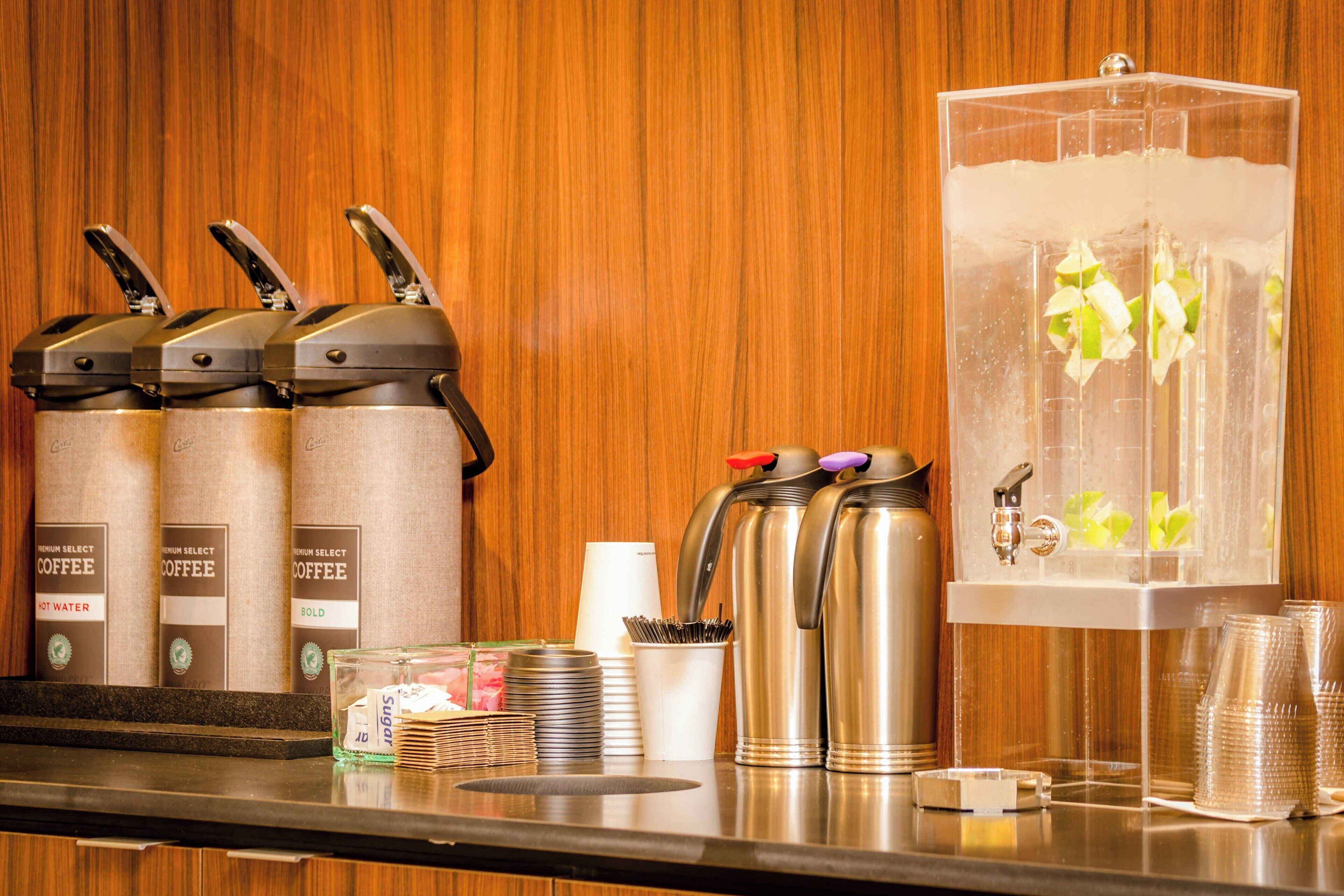A coffee station with multiple coffee dispensers and a water dispenser.