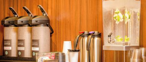 A coffee station with multiple coffee dispensers and a water dispenser.