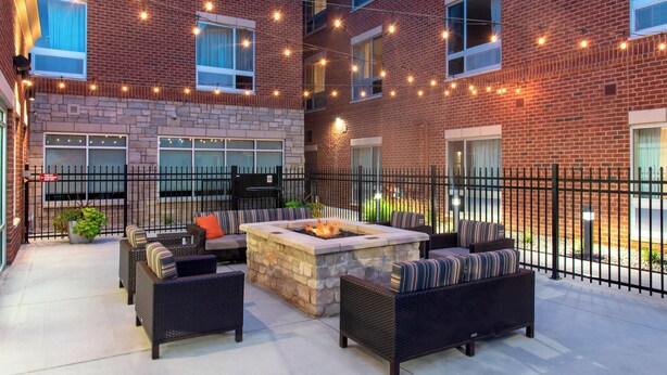 A brick building with outdoor seating and a fire pit.