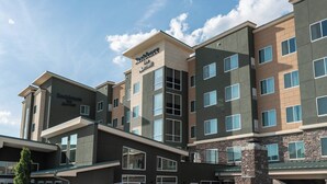 Un hotel de varios pisos con un diseño arquitectónico moderno, que presenta un cartel llamativo del Residence Inn Marriott.