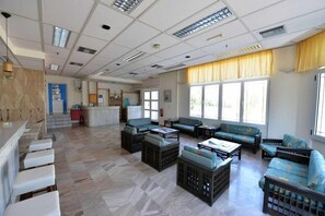 A spacious lobby with a reception desk, seating area with sofas and chairs, and large windows providing natural light. - Hotel Anna Apartments (Gouves)