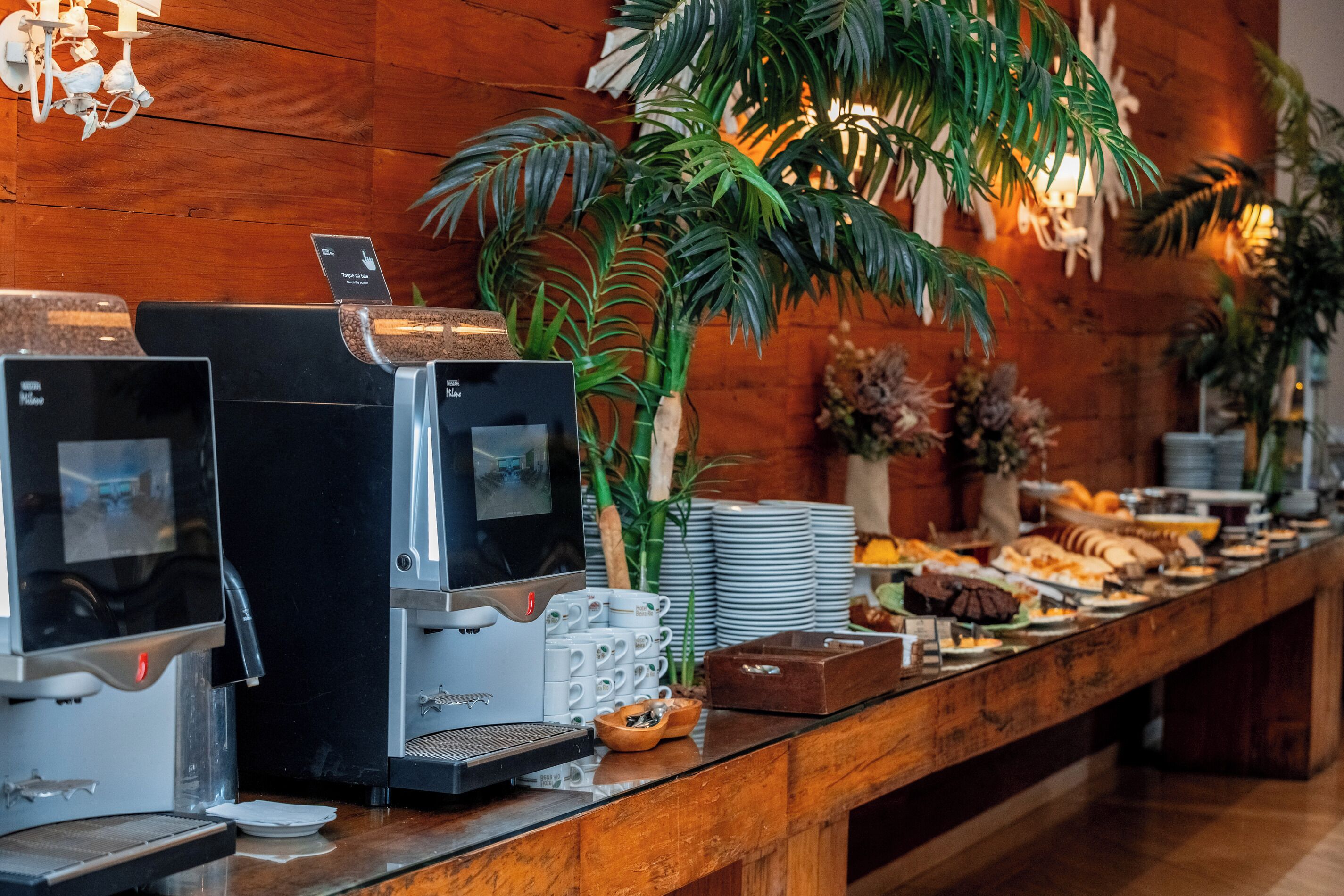 Een buffetopstelling met koffieautomaten, borden en kommen.
