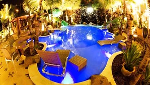 An outdoor swimming pool with lounge chairs and palm trees. - Beira Rio Palace Hotel (Piracicaba)