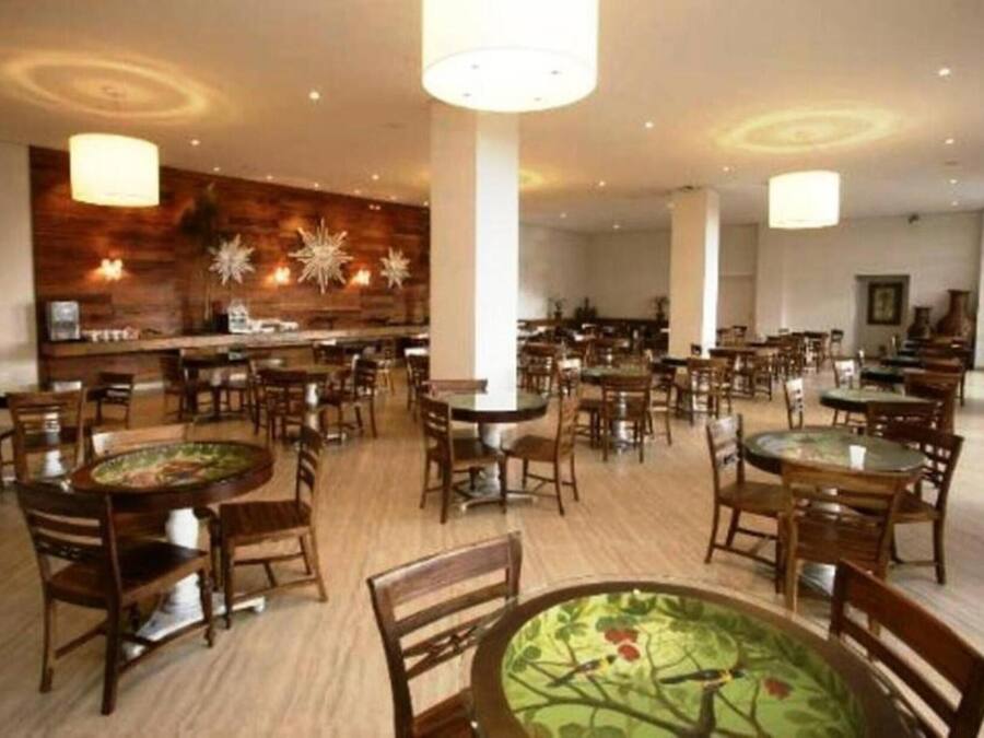 Un restaurante espacioso con varias mesas y sillas, una zona de bar y una pared decorativa con diseño de estrella.