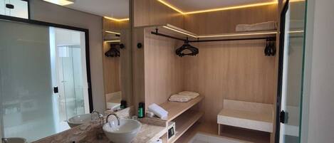A modern bathroom with a large mirror, two sinks, and a walk-in shower.