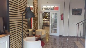 A modern interior with a desk, a lamp, a chair, and a small table. - Hotel Los Bartolos (Alhama de Murcia)