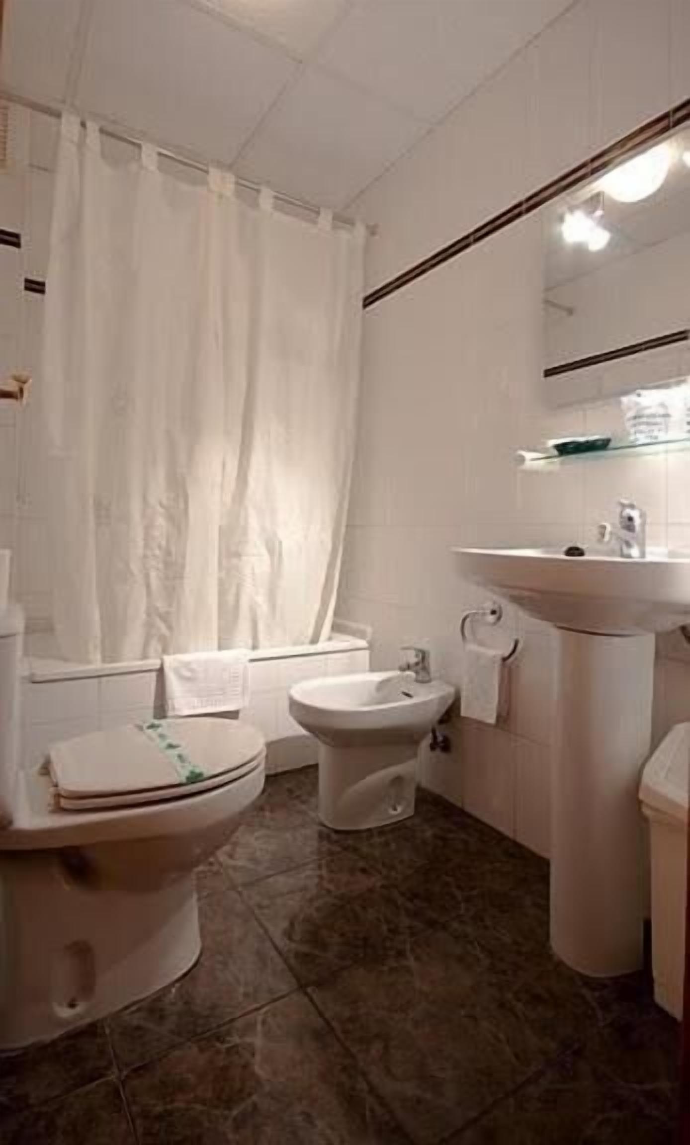 Un baño con inodoro, bidé y lavabo.