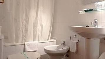 Un baño con inodoro, bidé y lavabo.