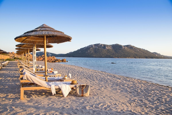 Playa privada, arena blanca, sillas reclinables de playa, sombrillas