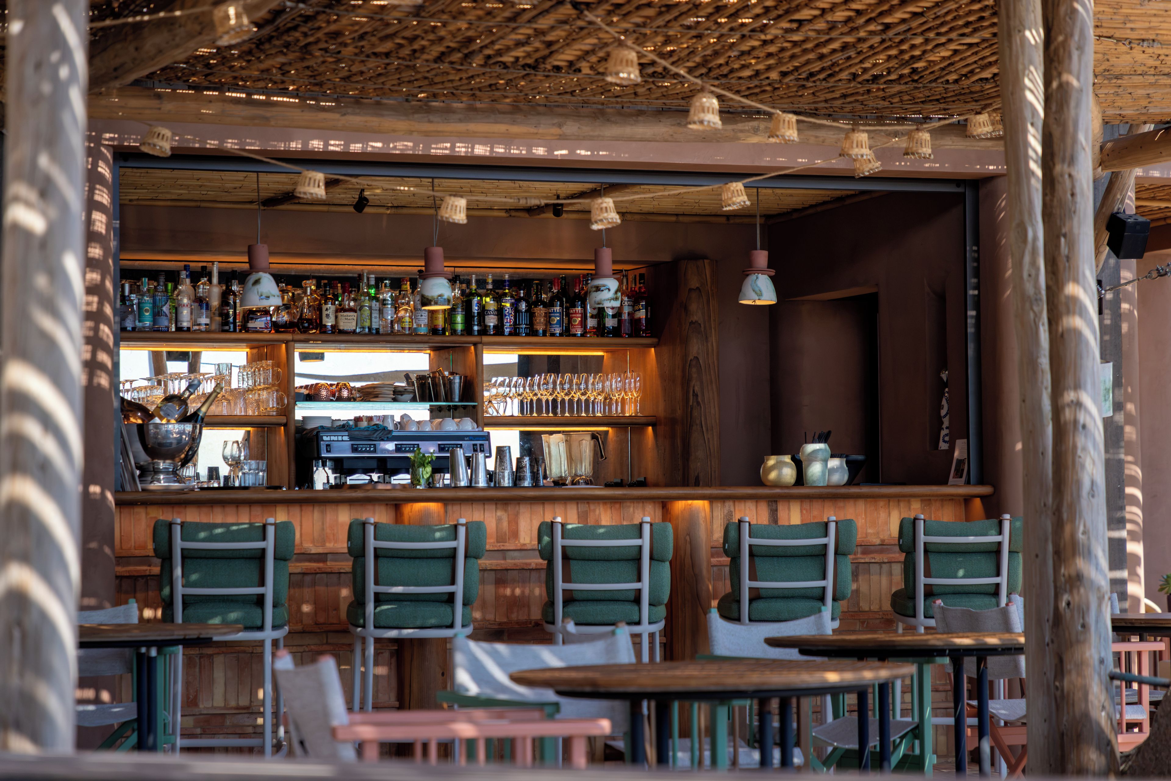 Un espace bar avec des meubles en bois et des luminaires suspendus.