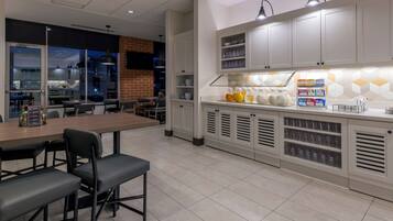 A modern kitchen with white cabinets, a central island, and a breakfast bar.