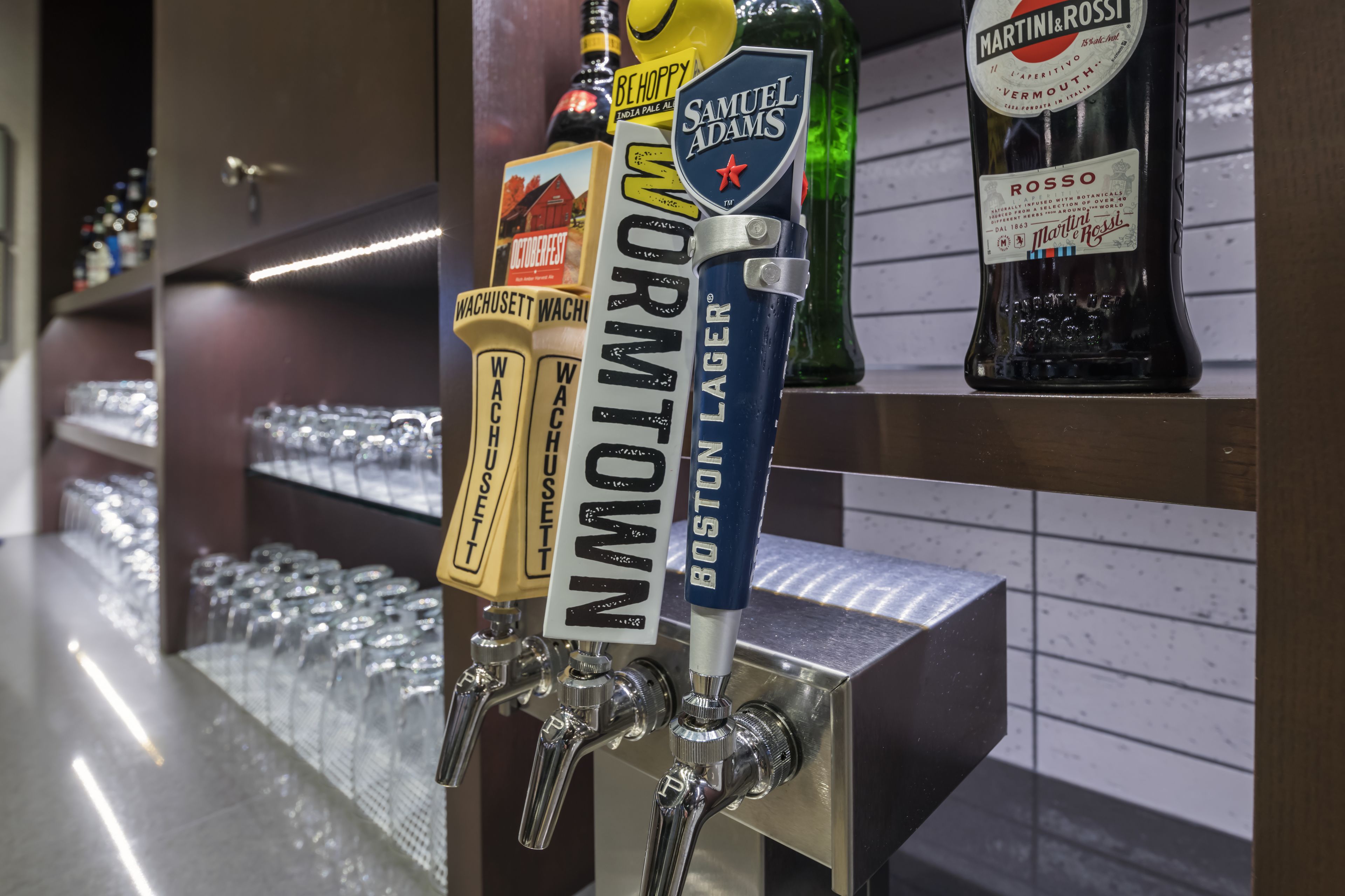 Un bancone bar con diverse spine di birra, tra cui marchi come Boston Lager e Samuel Adams.