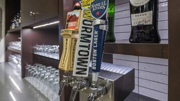 A bar with multiple beer taps, including brands like Boston Lager and Samuel Adams.