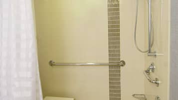 Un baño con bañera, ducha y barra de apoyo.