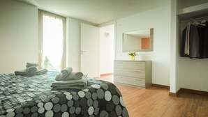 Ein Schlafzimmer mit einem Bett, einem Schminktisch, einem Spiegel und einem Kleiderschrank.
