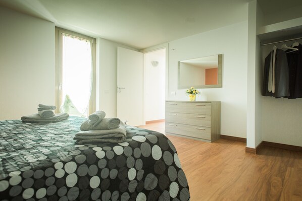 A bedroom with a bed, a dresser, a mirror, and a closet. - Il Crusco (Matera)