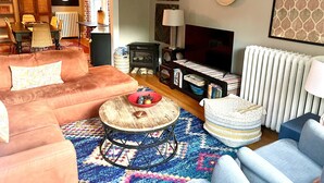 A cozy living room with a sofa, armchair, coffee table, and a fireplace. - Large, sunny 3 bedroom apartment two blocks from down town Oak Park.  (Oak Park)