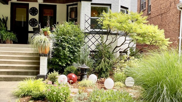 A modern two-story house with a white exterior, a black roof, and a brick wall adjacent to it. - Large, sunny 3 bedroom apartment two blocks from down town Oak Park.  (Oak Park)