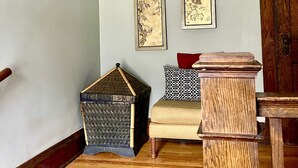 A room with a wooden cabinet, a small table, a patterned rug, and two wall-mounted decorative items. - Large, sunny 3 bedroom apartment two blocks from down town Oak Park.  (Oak Park)