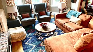 A living room with two armchairs, a sofa, a coffee table, and a patterned rug. - Large, sunny 3 bedroom apartment two blocks from down town Oak Park.  (Oak Park)