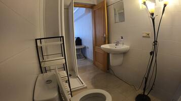 Een bad/douchecombinatie, een haardroger, handdoeken, toiletpapier