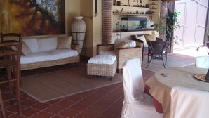 A cozy room with a sofa, wicker chairs, a dining table, and a fish tank. - SINGLE VILLA(VILLA "SOLE" BETWEEN ETNA AND TAORMINA THE SEA TO 2 KM (ACIREALE MANGANO)