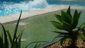 A pool with a waterfall feature, surrounded by a grassy area and potted plants. - SINGLE VILLA(VILLA "SOLE" BETWEEN ETNA AND TAORMINA THE SEA TO 2 KM (ACIREALE MANGANO)