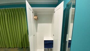 Una habitación con armario, espejo y suelo estampado.