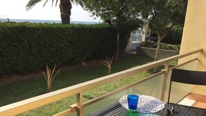 A balcony with a table, two glasses, and a chair.