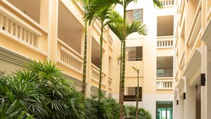 A hotel corridor with multiple floors, indoor plants, and a central pathway. - Park 38 Hotel (Wichit)