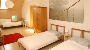 A bedroom with two single beds, a wooden wardrobe, a red rug, and a large painting of a rope bridge. - Beautiful, spacious apartment at the gates of the Hanseatic city of Rostock  (Lambrechtshagen)
