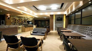 Un restaurant moderne avec des meubles en bois, un bar et un espace salon doté de bancs rembourrés.