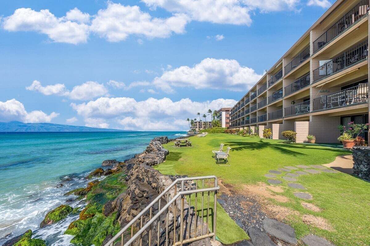 A hotel with a pool area, a view of the ocean, and a building with multiple balconies.