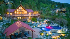A lodge with a large deck, a hot tub, and a pool surrounded by rocks. - Red Roof Lodge - Leavenworth (Leavenworth)
