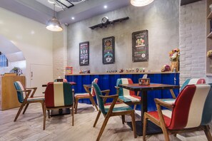 A cafe with wooden chairs and tables, a brick wall, and a clock. - J.T World FunTrip B&B (Hualien City)