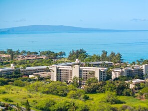 Un hotel frente al mar con varias construcciones, vistas al océano y vegetación circundante.