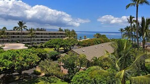A hotel with a view of the ocean, surrounded by palm trees and greenery. - Cozy Condo Near Beach w Ocean View Pool - Kihei Akahi C616 (Kihei)