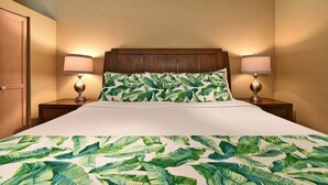 A hotel room with a bed, two bedside lamps, and a wooden headboard. - Cozy Condo Near Beach w Ocean View Pool - Kihei Akahi C616 (Kihei)