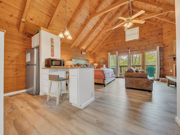 Una cabaña espaciosa con cocina, comedor y sala de estar.