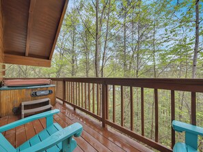 A wooden deck with a view of a forest.