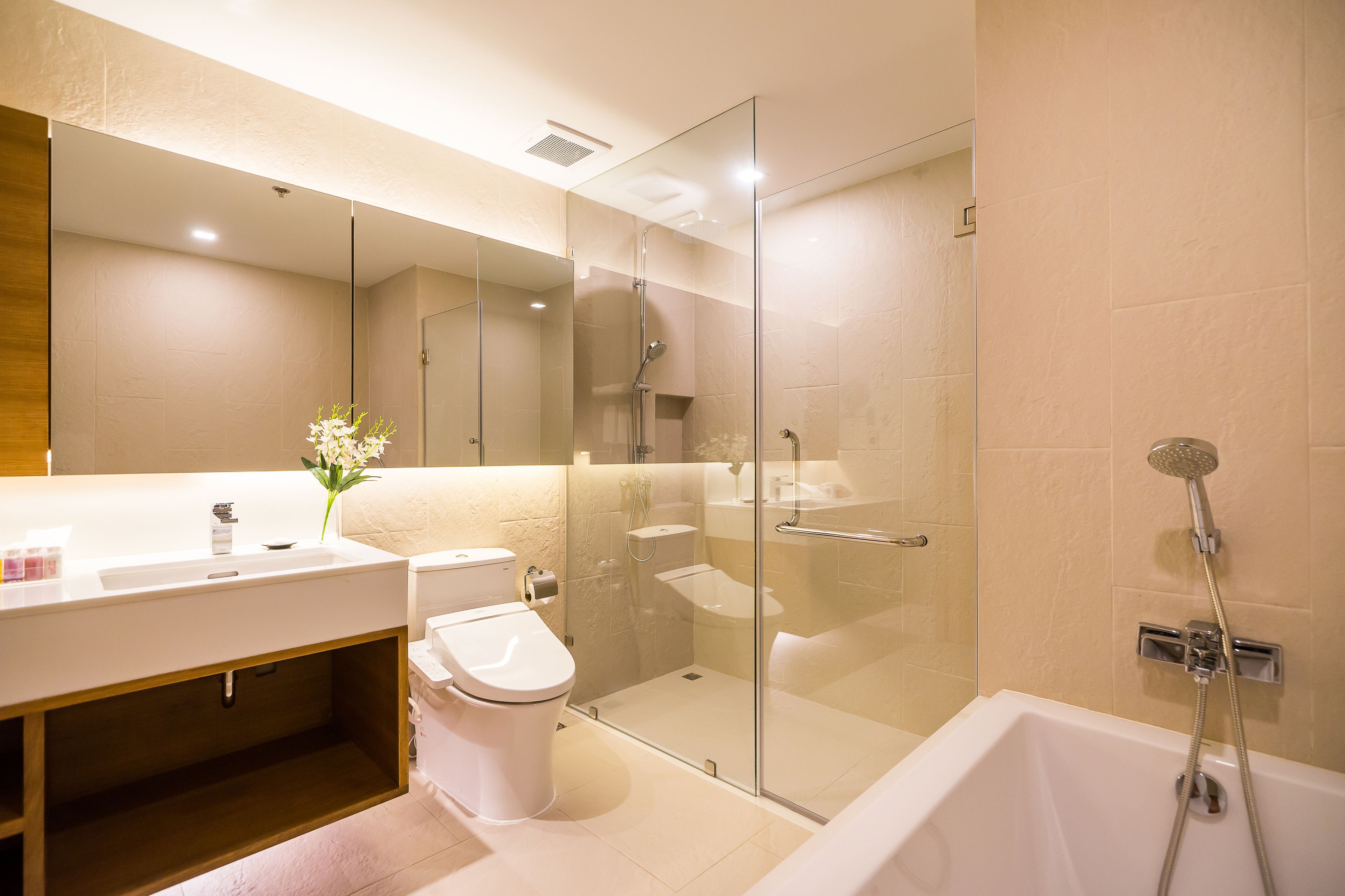 A modern bathroom with a glass-enclosed shower, a white sink, and a toilet.