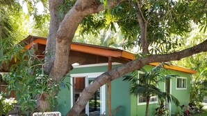 Un bâtiment vert avec une pancarte indiquant : « Stationnement de Mango Cottage ».
