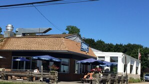 A restaurant with outdoor seating and a signboard.