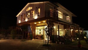 A two-story building with a balcony, a covered entrance, and outdoor seating. - Country View B&B (Ji'an)